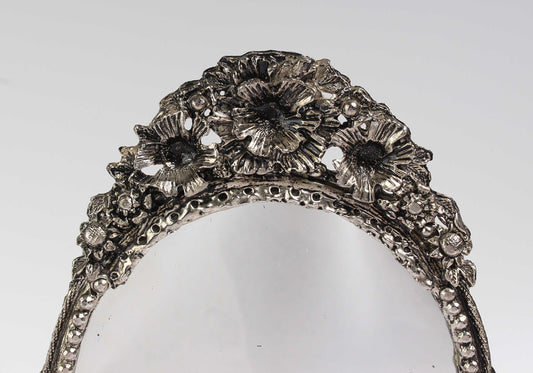 Gümüş yaprak figürleriyle dikkat çeken, 1980’lerde üretilmiş ve antika değerine sahip, estetik ve işlevsel dekoratif ayna.