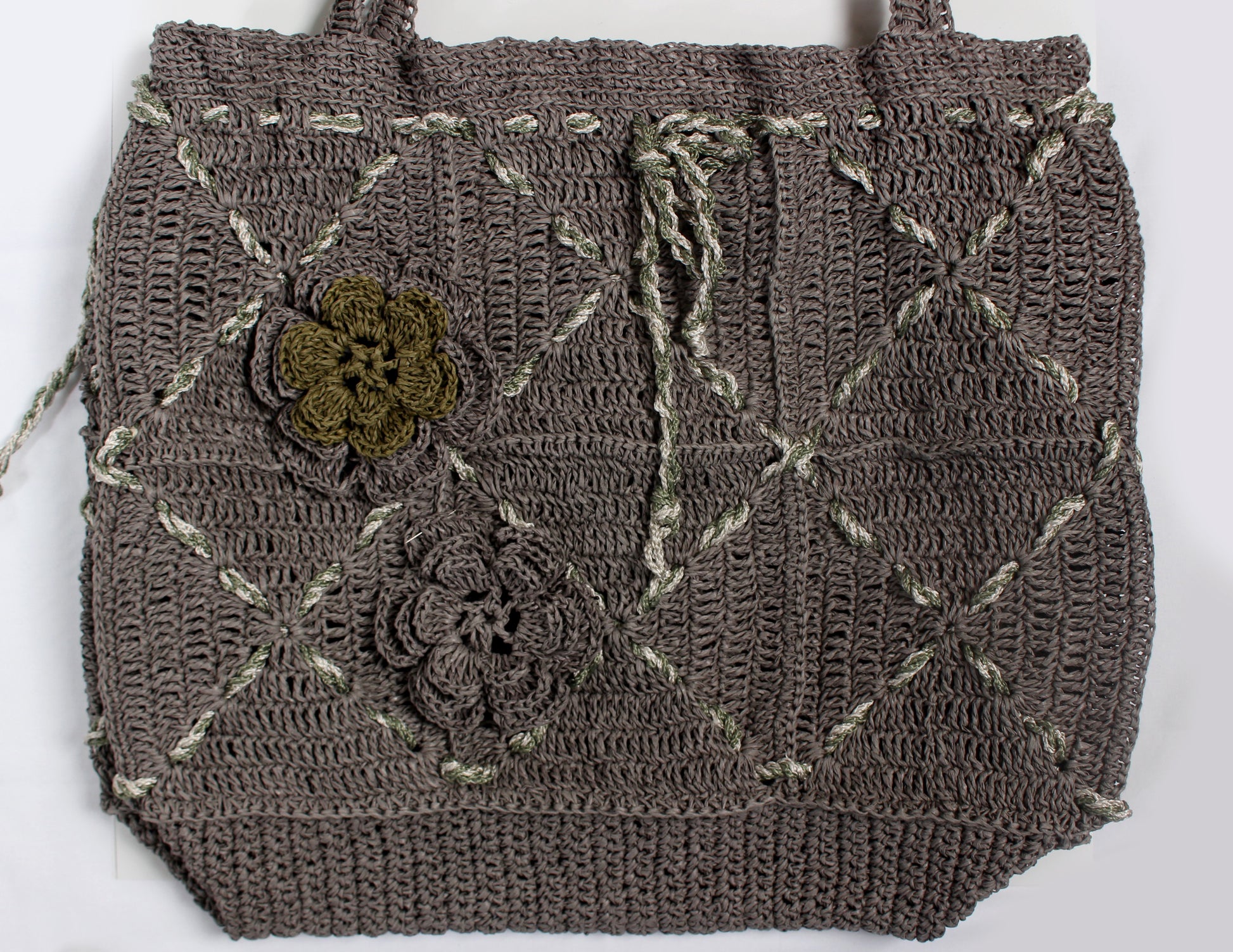 Elde bükülmüş floş kordonlarla süslenmiş gri kağıt iplikten yapılmış, iki renkli gül motifleriyle tamamlanan şık ve fonksiyonel çanta.