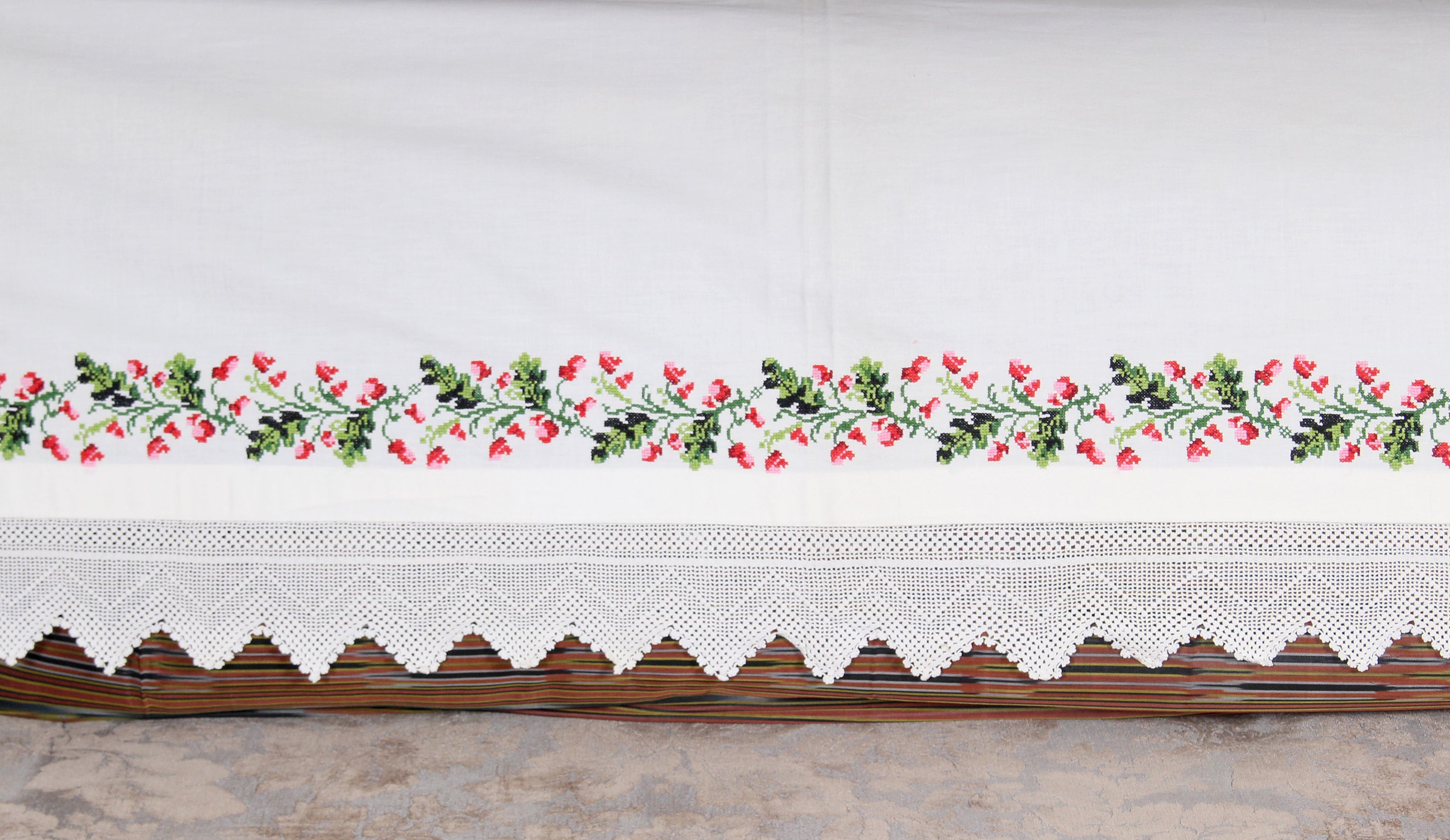 Kanaviçe tekniğiyle işlenmiş çiçek desenli el işi sedir örtüsü, dantel kenar detaylarıyla otantik dekoratif parça.